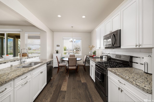 kitchen featuring gas range, white cabinets, dark hardwood / wood-style floors, and a healthy amount of sunlight