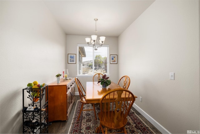 dining space featuring dark hardwood / wood-style floors and a chandelier