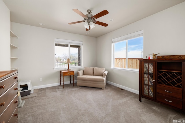 living area with carpet flooring, plenty of natural light, and ceiling fan