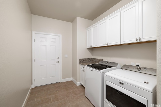 laundry room featuring washer and dryer, cabinets, and light tile floors