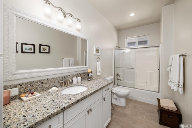 full bathroom with tile flooring, combined bath / shower with glass door, toilet, and vanity with extensive cabinet space