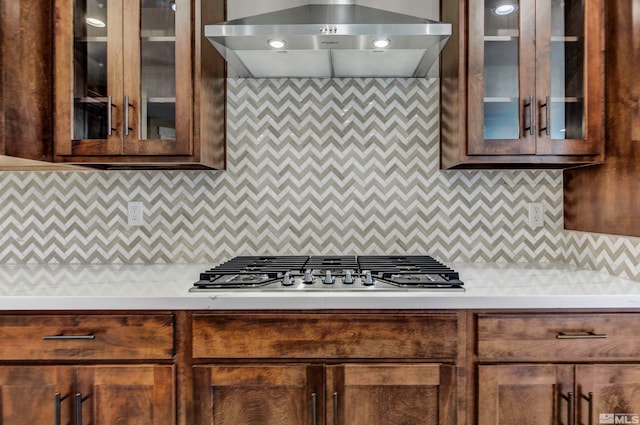 kitchen featuring wall chimney range hood, backsplash, and stainless steel gas stovetop