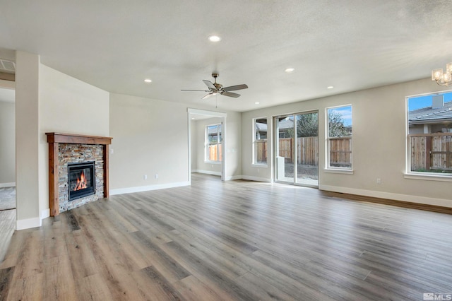 unfurnished living room with ceiling fan, a textured ceiling, and light wood-type flooring