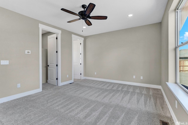 spare room featuring light colored carpet and ceiling fan