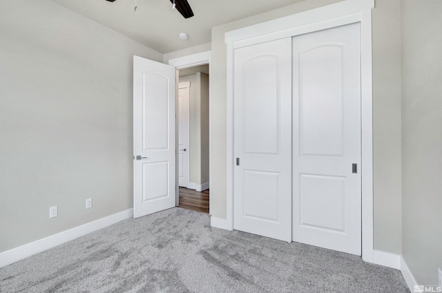 unfurnished bedroom featuring ceiling fan, light carpet, and a closet