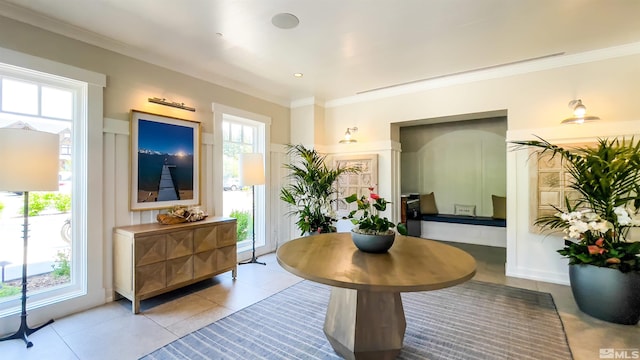 interior space with a wealth of natural light, light tile floors, and ornamental molding