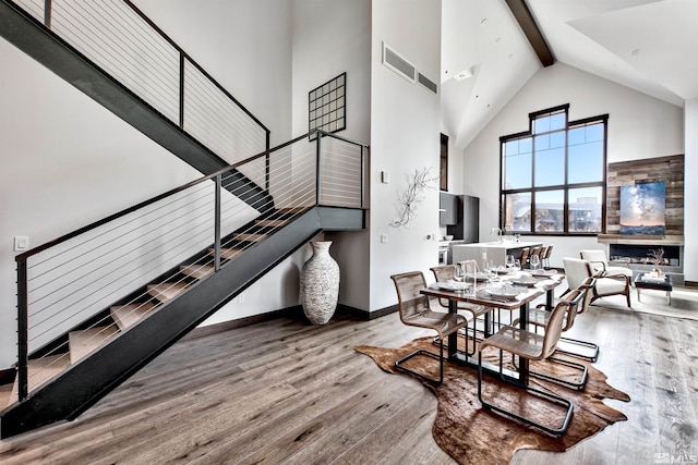 interior space featuring beamed ceiling, high vaulted ceiling, and light wood-type flooring