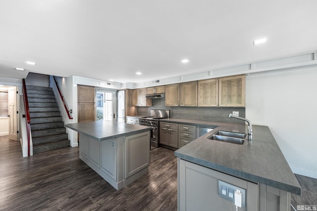 kitchen featuring a center island, sink, dark hardwood / wood-style flooring, and stainless steel stove