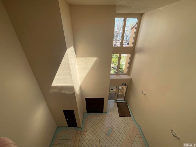 stairway with tile patterned floors and a wealth of natural light