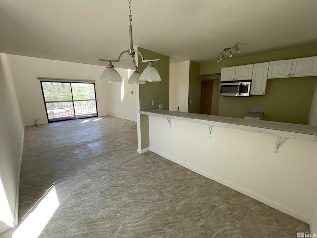 kitchen featuring a breakfast bar, white cabinets, hanging light fixtures, and an inviting chandelier