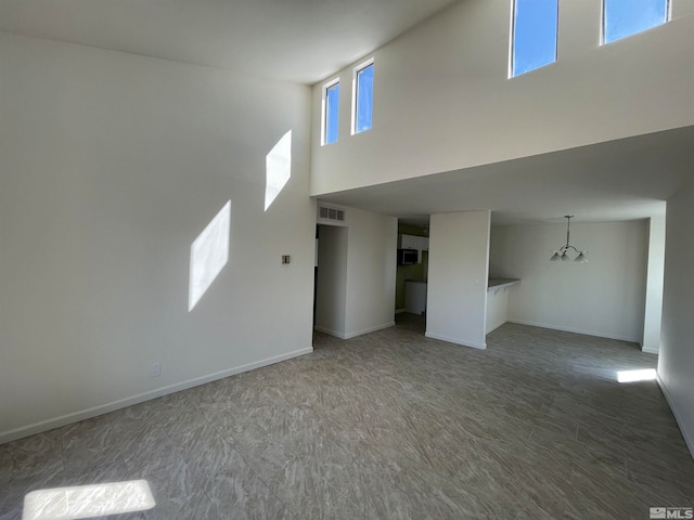 unfurnished living room featuring a high ceiling