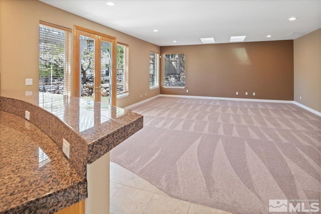 carpeted spare room featuring french doors