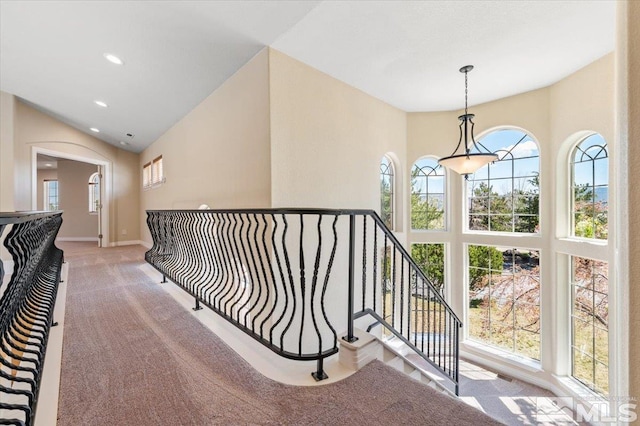 hallway featuring light colored carpet and lofted ceiling