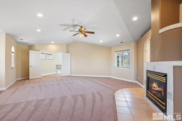 unfurnished living room featuring light colored carpet, vaulted ceiling, and ceiling fan