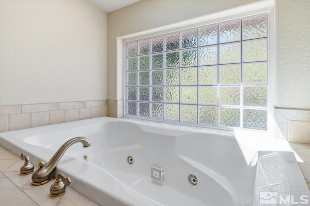 bathroom featuring a healthy amount of sunlight and tiled bath