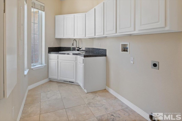 laundry area with light tile flooring, hookup for an electric dryer, hookup for a washing machine, sink, and cabinets