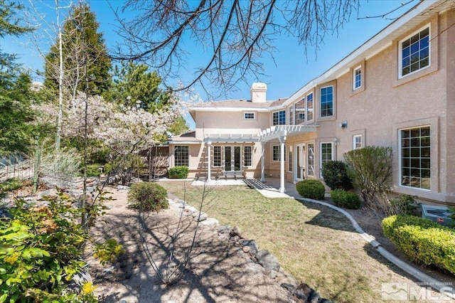 rear view of property featuring a patio area, a lawn, and a pergola