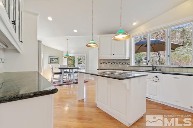 kitchen featuring light wood-type flooring, hanging light fixtures, white cabinetry, and lofted ceiling