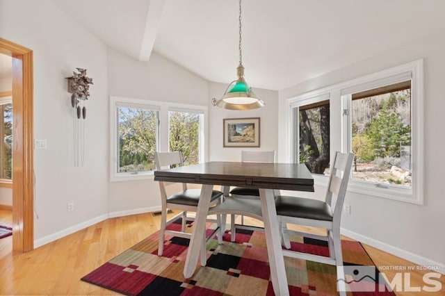 dining room with lofted ceiling with beams, wood-type flooring, and a wealth of natural light