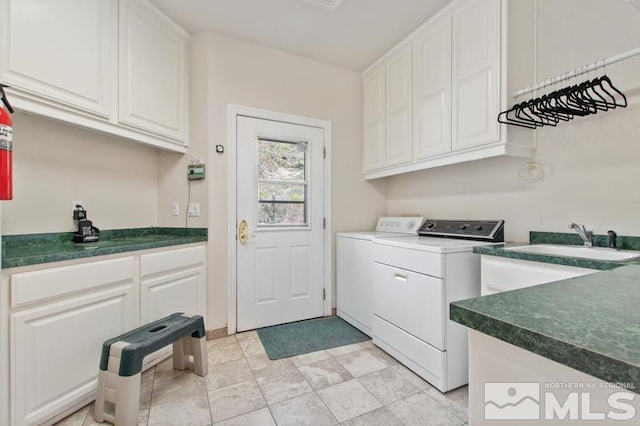 laundry room featuring sink, light tile flooring, cabinets, and washer and clothes dryer