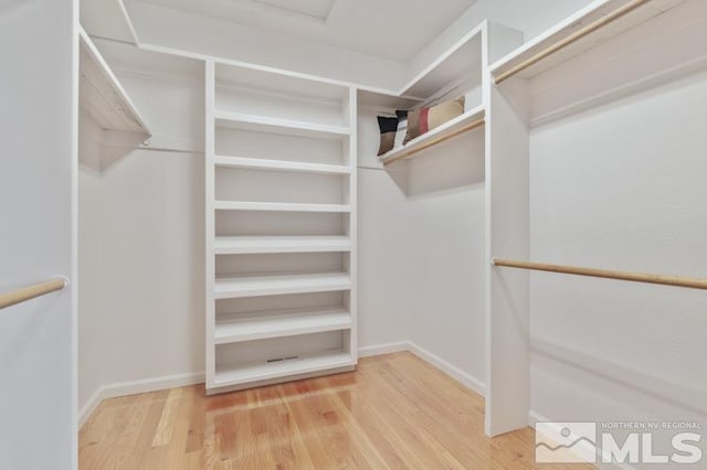 spacious closet featuring light hardwood / wood-style floors