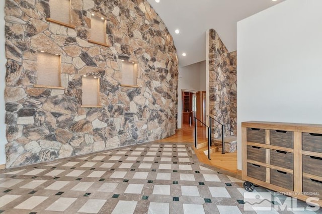 tiled empty room featuring lofted ceiling