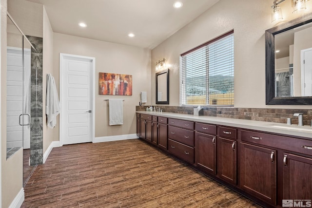 bathroom featuring backsplash, double sink, hardwood / wood-style flooring, and large vanity