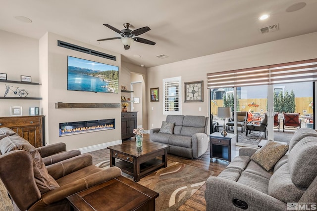 living room featuring wood-type flooring and ceiling fan