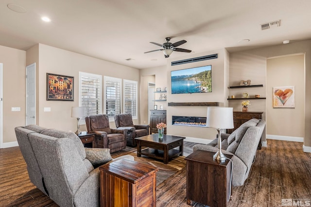 living room with ceiling fan and dark wood-type flooring