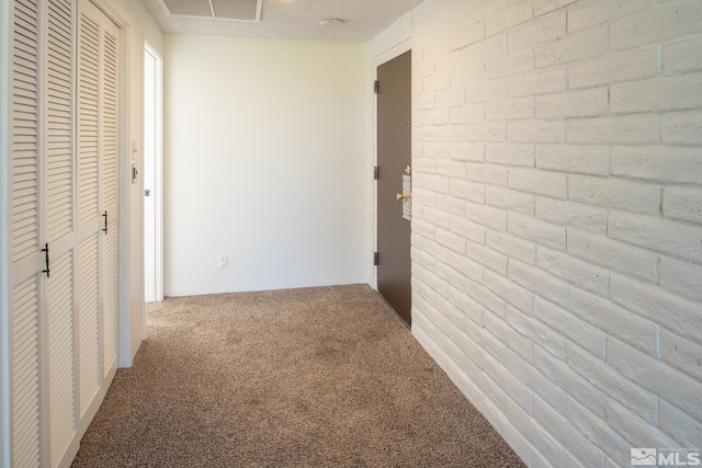 hallway with carpet floors and a textured ceiling