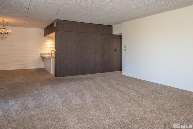 spare room with carpet and an inviting chandelier