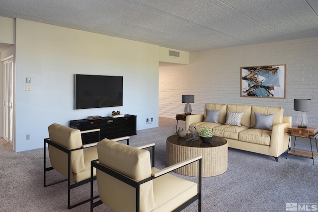 carpeted living room featuring brick wall and a textured ceiling