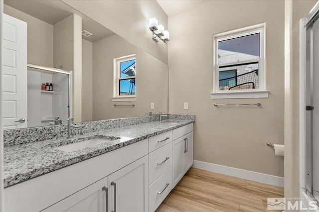 bathroom with hardwood / wood-style flooring and double vanity