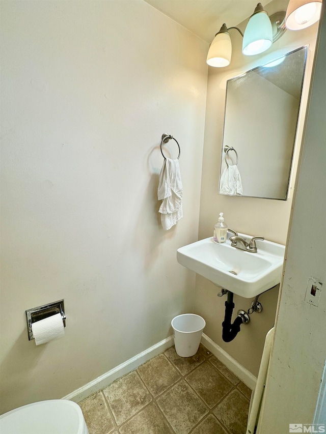 bathroom featuring toilet, tile floors, and sink