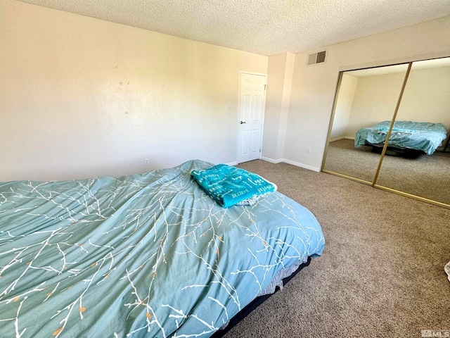 bedroom with carpet flooring, a closet, and a textured ceiling