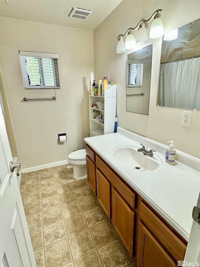 bathroom featuring toilet, tile floors, and vanity