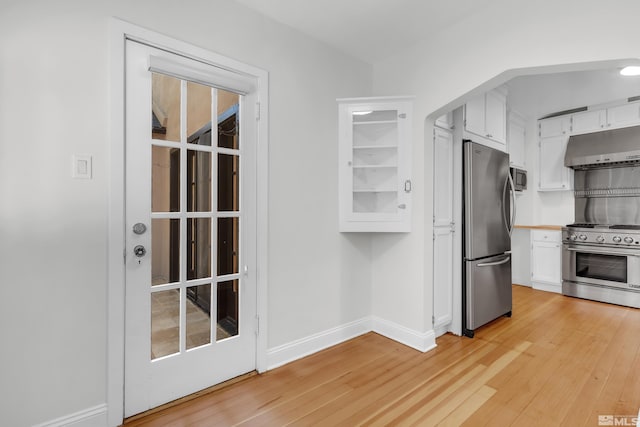 kitchen with stainless steel appliances, light wood-type flooring, and white cabinetry