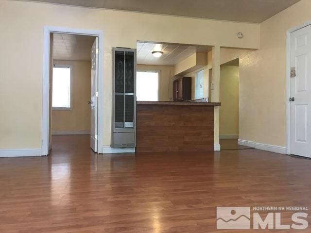 kitchen featuring dark hardwood / wood-style flooring, kitchen peninsula, and a wealth of natural light