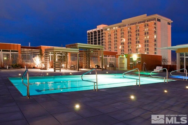 pool at night with a patio area