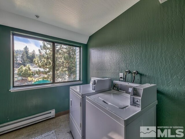 laundry room featuring washer and dryer, light tile floors, and baseboard heating