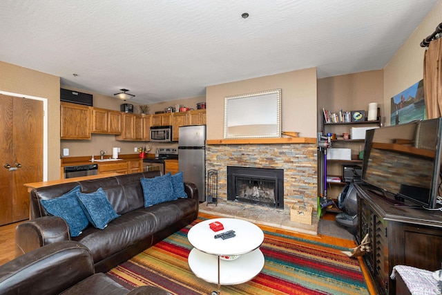 living room with a fireplace, sink, and a textured ceiling