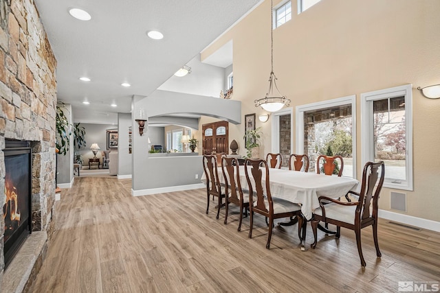 dining room featuring a stone fireplace and hardwood / wood-style flooring