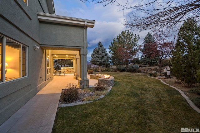 yard at dusk featuring a patio