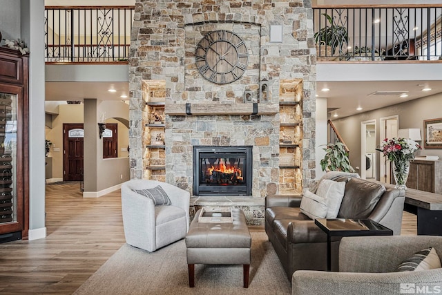 living room featuring a high ceiling, hardwood / wood-style floors, and a fireplace