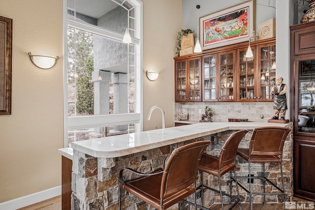 bar featuring backsplash, pendant lighting, and wood-type flooring