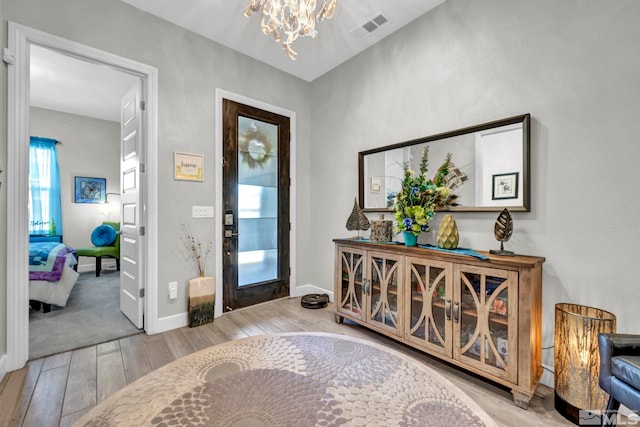 carpeted entryway featuring a chandelier