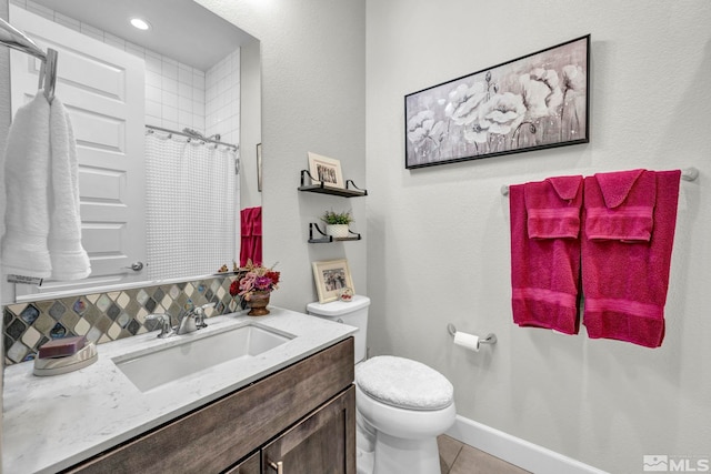 bathroom with tile flooring, vanity, backsplash, and toilet