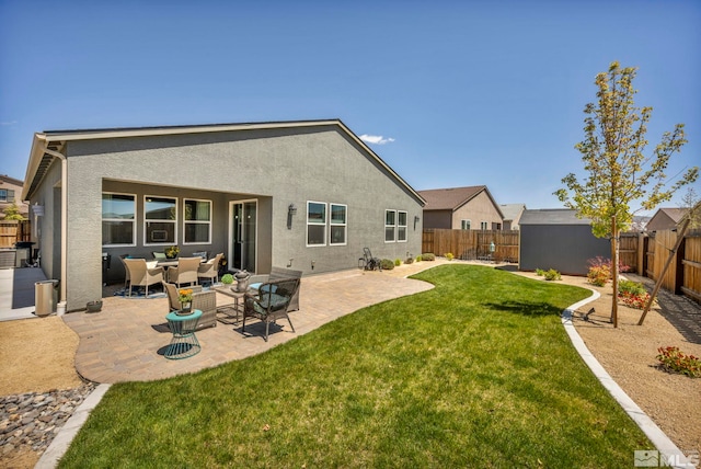 back of house with a patio area, a yard, and an outdoor hangout area