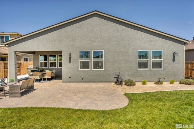 back of property featuring a yard, an outdoor hangout area, and a patio