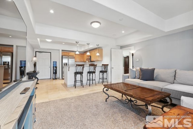 carpeted living room with a raised ceiling